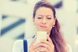 Closeup side profile portrait upset sad skeptical unhappy serious woman talking texting on phone displeased with conversation isolated city background. Negative human emotion face expression feeling