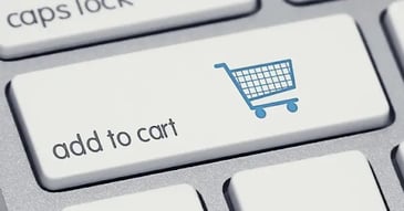 A close-up image of a white key on a gray keyboard with an image of a shopping cart next to the words 